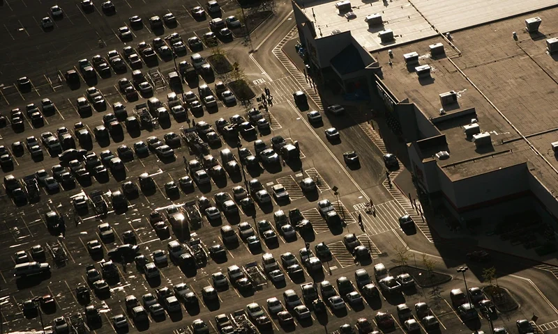 Wal-Mart Dominates U.S. Retail Economy BOWLING GREEN, OH - MAY 10: Cars lie in the parking lot of a Wal-Mart as the sun sets May 10, 2005 in Bowling Green, Ohio. Wal-Mart, America's largest retailer and the largest company in the world based on revenue, has evolved into a giant economic force for the U.S. economy. With growth, the company continues to weather criticism of low wages, anti-union policies as well as accusations that it has homogenized America's retail economy and driven traditional stores and shops out of business. (Photo by Chris Hondros/Getty Images)