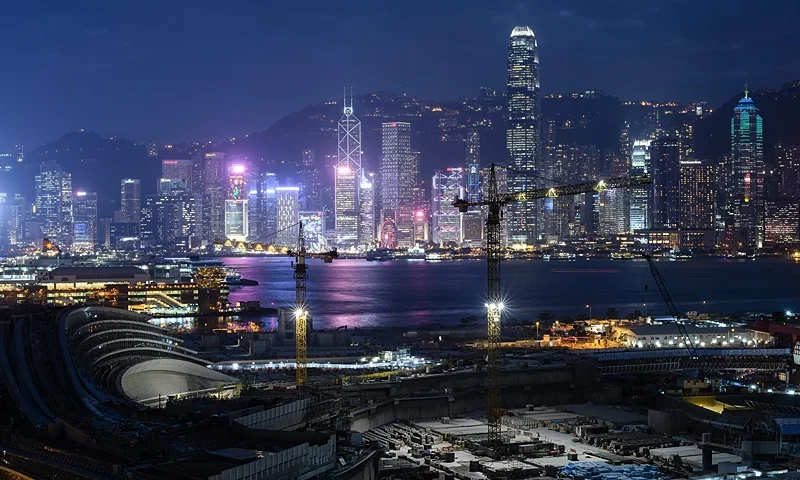 TOPSHOT - A long exposure general view shows the construction site (foreground) of the West Kowloon terminus of the high-speed rail link which will connect the city to the southern Chinese city of Guangzhou, as Hong Kong's skyline looms in the background on December 27, 2017. China's top legislative body decreed on December 27 that Chinese officials could enforce mainland law in part of a new railway station in Hong Kong, despite protests that this would erode the city's autonomy. (Photo by Anthony WALLACE / AFP) (Photo by ANTHONY WALLACE/AFP via Getty Images)