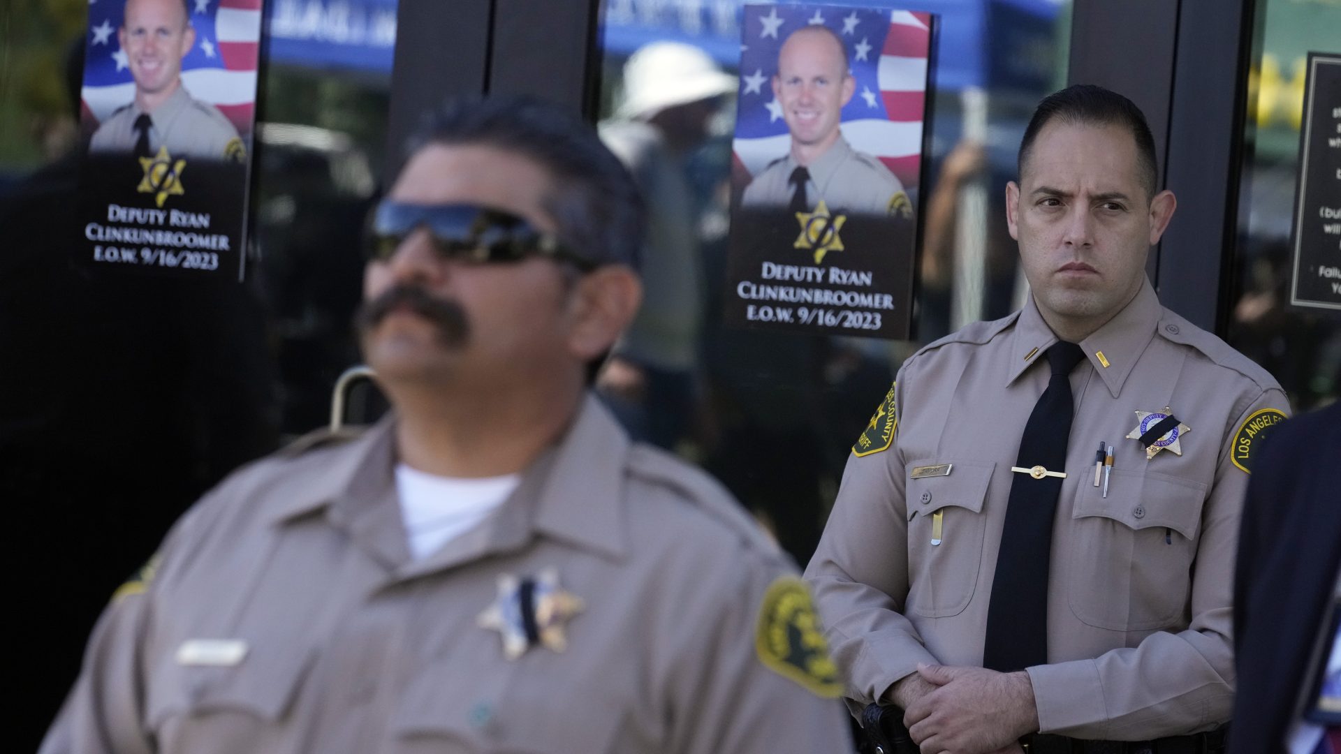 Photos of Los Angeles County sheriffs deputy Ryan Clinkunbroomer are placed at the entrance of the Palmdale Sheriff's Station during a press to announce an arrest in the ambush killing of Clinkunbroomer Monday, Sept. 18, 2023, in Palmdale, Calif. Clinkunbroomer was shot and killed while sitting in his patrol car Saturday evening in Palmdale. (AP Photo/Marcio Jose Sanchez)