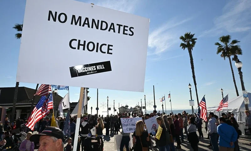 People demonstrate against Covid-19 vaccine mandates for students in Huntington Beach, California on January 3, 2022. - The Los Angeles Unified School District (LAUSD) announced in mid-December its decision to delay until fall 2022 its Covid-19 vaccine mandate for students 12 and older who attend class in person. The original deadline for in-person students to show proof of full vaccination was January 10, 2022. (Photo by Robyn Beck / AFP) (Photo by ROBYN BECK/AFP via Getty Images)