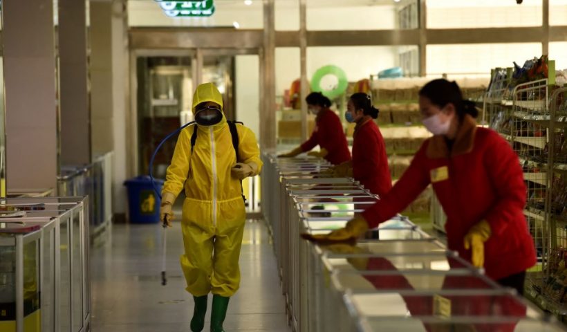 TOPSHOT - Employees spray disinfectant and wipe surfaces as part of preventative measures against the Covid-19 coronavirus at the Pyongyang Children's Department Store in Pyongyang on March 18, 2022. (Photo by KIM Won Jin / AFP) (Photo by KIM WON JIN/AFP via Getty Images)