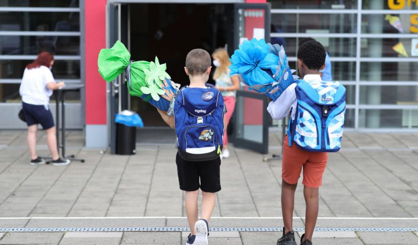 OBERPLEIS, GERMANY - AUGUST 13: First graders arrive with goodie bags for their first introductory day to school during the coronavirus pandemic on August 13, 2020 in Oberpleis near Bonn, Germany. Classes at schools across Germany are beginning this month with face mask requirements varying by state. Coronavirus infection rates are climbing again in Germany, from an average of 400 new cases per day about two weeks ago up to over 1,300 in recent days, according to the Robert Koch Institute. (Photo by Andreas Rentz/Getty Images)