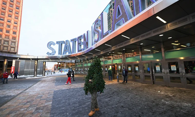 NEW YORK, NEW YORK - DECEMBER 18: Tommy Liberto walks out of the Staten Island ferry terminal after arriving in NYC wearing a Christmas tree costume on December 18, 2020 in New York City. Liberto has traveled to New York City and Los Angeles from Maryland for the past six years in his Christmas tree costume to help spread joy throughout the holidays. (Photo by Michael M. Santiago/Getty Images)