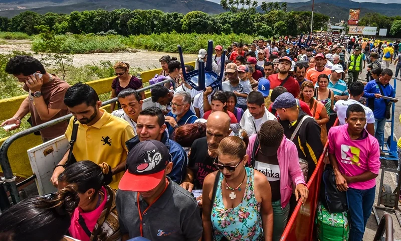 TOPSHOT-COLOMBIA-VENEZUELA-MIGRATION TOPSHOT - Venezuelan citizens enter Cucuta, Norte de Santander Department, Colombia from San Antonio del Tachira, Venezuela at the Simon Bolivar international bridge on July 25, 2017. - Some 25.000 Venezuelans cross to Colombia and return to their country daily with food, consumables and money from ilegal work, according to official sources. Also, there are 47.000 Venezuelans in Colombia with legal migratory status and another 150.000 who have already completed the 90 allowed days and are now without visa. (Photo by Luis Acosta / AFP) (Photo by LUIS ACOSTA/AFP via Getty Images)
