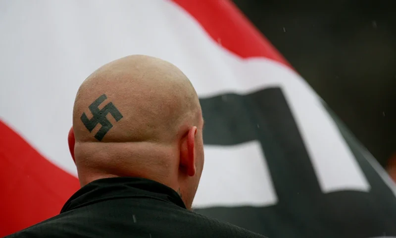 Neo-Nazis Protest Outside Skokie Holocaust Museum Dedication SKOKIE, IL - APRIL 19: Neo-Nazi protestors organized by the National Socialist Movement demonstrate near where the grand opening ceremonies were held for the Illinois Holocaust Museum & Education Center April 19, 2009 in Skokie, Illinois. About 20 protestors greeted those who left the event with white power salutes and chants. (Photo by Scott Olson/Getty Images)