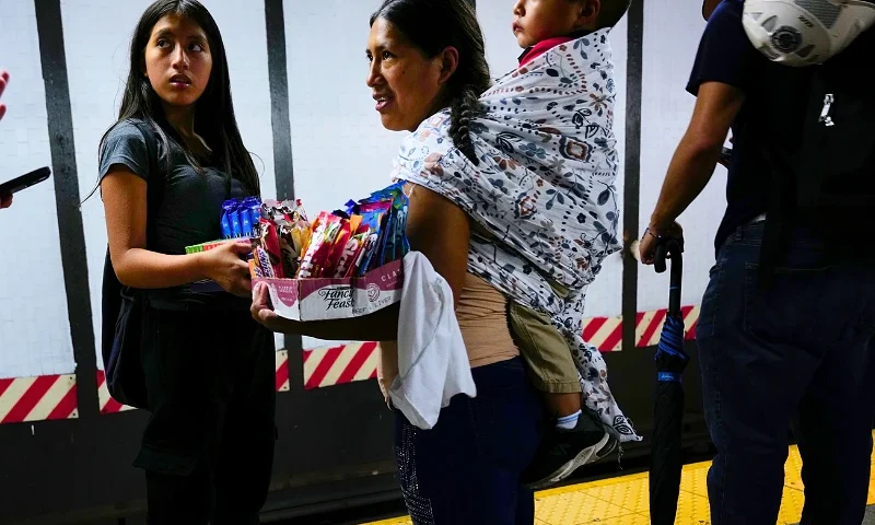 NEW YORK, NEW YORK - AUGUST 18: A teenager and a woman sell candy and other items in a New York City subway car on August 18, 2023 in New York City. Over 70,000 asylum-seekers have arrived in New York City since last year, according to City Hall, and many have taken to selling items on the streets and subways of the city. Children and young adults selling candy, snacks and drinks in subway stations and cars are an increasingly common site in New York as families look to make ends meet financially as many do not have work permits. (Photo by Spencer Platt/Getty Images)