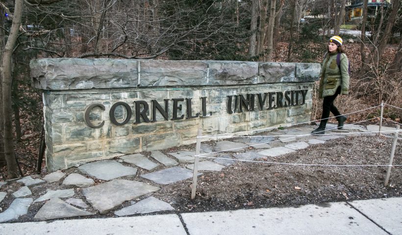 FILE - A woman walks by a Cornell University sign on the Ivy League school's campus in Ithaca, New York, on Jan. 14, 2022. Cornell University administrators dispatched campus police to a Jewish center after threatening statements appeared on a discussion board Sunday, Oct. 29, 2023. (AP Photo/Ted Shaffrey, File)