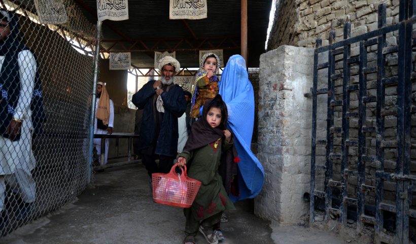 TOPSHOT - In this picture taken on November 21, 2022, Afghans walk along a fenced corridor as they cross into Pakistan at the Afghanistan-Pakistan border in Spin Boldak. (Photo by AFP) (Photo by -/AFP via Getty Images)