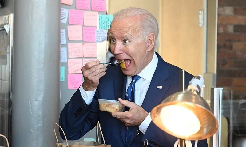 TOPSHOT - US President Joe Biden samples peach cobbler with Cincinnati mayor Aftab Pureval at Just Q'in barbecue restaurant in Cincinnati, Ohio,, on January 4, 2023. (Photo by Jim WATSON / AFP) (Photo by JIM WATSON/AFP via Getty Images)