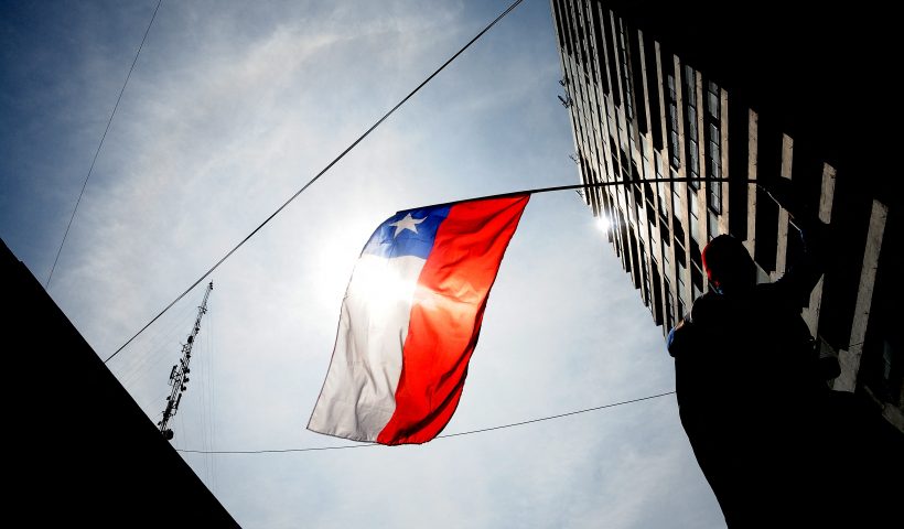 TOPSHOT - A man affected by the massive earthquake of February 27, 2010 in Chile, waves a Chilean national flag during a march on the first anniversary of quake to protest against the government for the slow progress in the reconstruction works, in Concepcion, around 520 km south of Santiago on February 26, 2011. AFP PHOTO/ARIEL MARINKOVIC (Photo by ARIEL MARINKOVIC / AFP) (Photo by ARIEL MARINKOVIC/AFP via Getty Images)