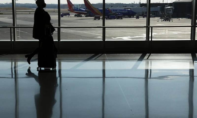 Holiday Travel Expected To Rise Over 25 Percent Over 2020 Despite COVID-19 Uptick BALTIMORE, MARYLAND - DECEMBER 22: A passenger walks through a terminal at Baltimore/Washington International Thurgood Marshall Airport (BWI) on December 22, 2021 in Baltimore, Maryland. AAA predicted more than 109 million Americans will travel 50 miles or more over Christmas and New Year holidays, a spike of 27.7% over last year. (Photo by Alex Wong/Getty Images)