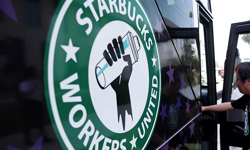 LOS ANGELES, CALIFORNIA - JULY 28: A Starbucks worker boards the Starbucks union bus after Starbucks workers stood on the picket line with striking SAG-AFTRA and Writers Guild of America (WGA) members in solidarity outside Netflix studios on July 28, 2023 in Los Angeles, California. The show of support is part of a Starbucks Workers United ‘The Union is Calling’ summer bus tour across 13 cities in an effort to unionize more Starbucks stores with workers calling for a living wage and other protections amid a so-called ‘hot labor summer’. (Photo by Mario Tama/Getty Images)