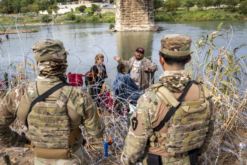 Surge In Migration Overwhelms Texas Border City Of Eagle Pass
EAGLE PASS, TEXAS - SEPTEMBER 27: Venezuelan immigrant Louis Sanchez asks Texas National Guard troops to let his family pass through razor wire after they crossed the Rio Grande from Mexico on September 27, 2023 in Eagle Pass, Texas. A surge of migrants crossing the U.S. southern border seeking asylum has put pressure on U.S. immigration authorities, reaching record levels during the last week. (Photo by John Moore/Getty Images)