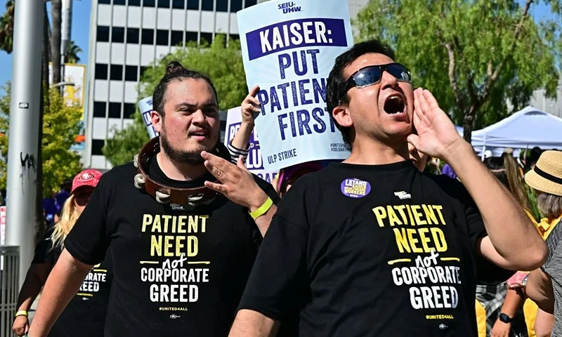 TOPSHOT - Kaiser Permanente health care employees, joind by Union members representing workers, walk the picket line in Los Angeles during the second day of their strike on October 5, 2023. More than 75,000 employees at Kaiser Permanente began one of the largest healthcare worker strikes in recent US history on October 4 after failing to resolve a dispute over staffing levels. (Photo by Frederic J. BROWN / AFP) (Photo by FREDERIC J. BROWN/AFP via Getty Images)