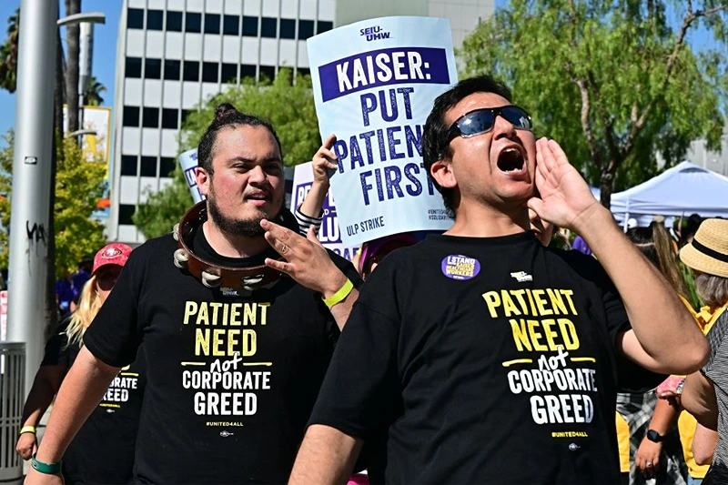 TOPSHOT - Kaiser Permanente health care employees, joind by Union members representing workers, walk the picket line in Los Angeles during the second day of their strike on October 5, 2023. More than 75,000 employees at Kaiser Permanente began one of the largest healthcare worker strikes in recent US history on October 4 after failing to resolve a dispute over staffing levels. (Photo by Frederic J. BROWN / AFP) (Photo by FREDERIC J. BROWN/AFP via Getty Images)