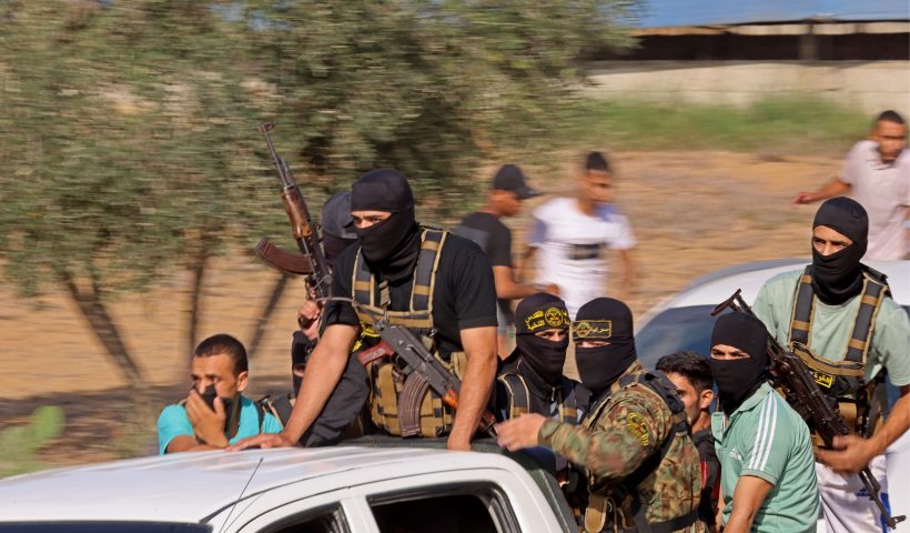 TOPSHOT - Palestinian militants move towards the border fence with Israel from Khan Yunis in the southern Gaza Strip on October 7, 2023. Barrages of rockets were fired at Israel from the Gaza Strip at dawn as militants from the blockaded Palestinian enclave infiltrated Israel, with at least one person killed, the army and medics said. (Photo by SAID KHATIB / AFP) (Photo by SAID KHATIB/AFP via Getty Images)
