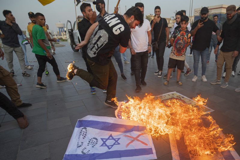 TOPSHOT - Iraqis burn Israeli flags during a rally held in central Baghdad on October 7, 2023 in support of the Palestinians, after Hamas militants launched a deadly air, land and sea assault into Israel from the Gaza Strip. (Photo by Murtadha Ridha / AFP) (Photo by MURTADHA RIDHA/AFP via Getty Images)