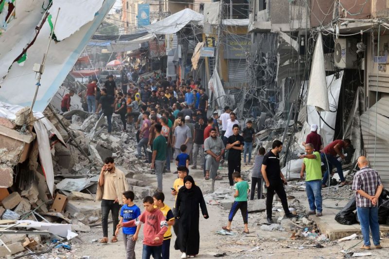 TOPSHOT - Palestinians walk amid the rubble of destroyed and damaged building in the heavily bombarded city center of Khan Yunis in the southern Gaza Strip following overnight Israeli shelling, on October 10, 2023. Israel pounded Hamas targets in Gaza on October 10 and said the bodies of 1,500 Islamist militants were found in southern towns recaptured by the army in gruelling battles near the Palestinian enclave. (Photo by SAID KHATIB / AFP) (Photo by SAID KHATIB/AFP via Getty Images)