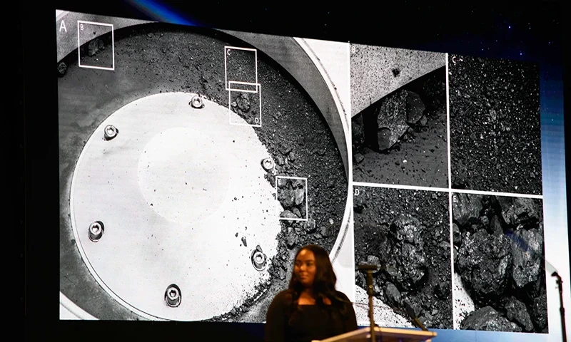 US-SPACE-ASTRONOMY-NASA A picture of some of the sample matter collected from the asteroid is displayed during a press conference for the OSIRIS-REx sample unveiling at the Johnson Space Center in Houston, Texas on October 11, 2023. A sample collected from the 4.5-billion-year-old asteroid Bennu contains abundant water and carbon, NASA revealed on Wednesday, offering more evidence for the theory that life on Earth was seeded from outer space. (Photo by Mark Felix / AFP) (Photo by MARK FELIX/AFP /AFP via Getty Images)