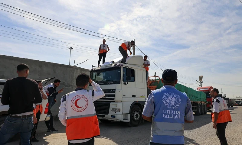TOPSHOT-PALESTINIAN-EGYPT-ISRAEL-CONFLICT-AID TOPSHOT - Aid workers gather around trucks carrying humanitarian aid that entered the Gaza Strip from Egypt via the Rafah border crossing on October 21, 2023. The first of 20 trucks carrying humanitarian aid entered the war-torn and besieged Gaza Strip on October 21 through the Rafah border crossing with Egypt, said AFP correspondents on both sides. (Photo by SAID KHATIB / AFP) (Photo by SAID KHATIB/AFP via Getty Images)
