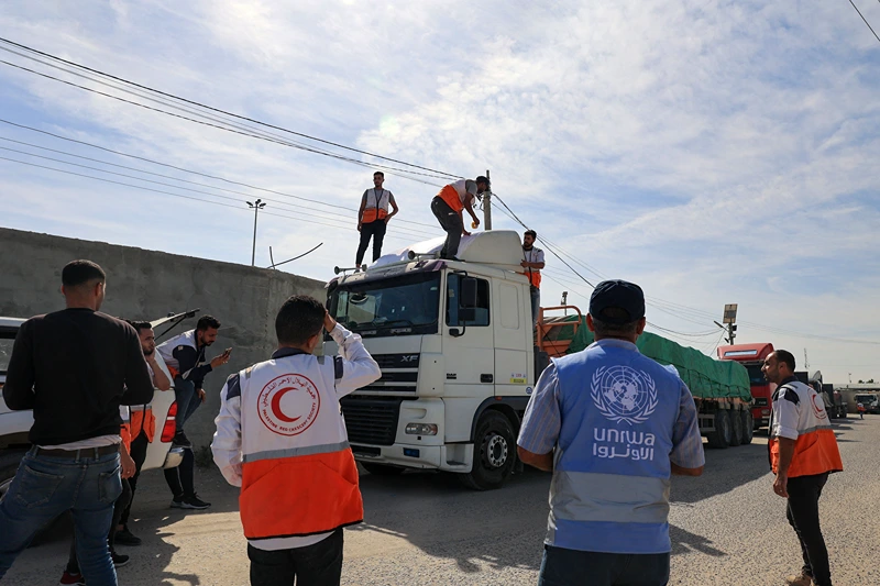 TOPSHOT-PALESTINIAN-EGYPT-ISRAEL-CONFLICT-AID
TOPSHOT - Aid workers gather around trucks carrying humanitarian aid that entered the Gaza Strip from Egypt via the Rafah border crossing on October 21, 2023. The first of 20 trucks carrying humanitarian aid entered the war-torn and besieged Gaza Strip on October 21 through the Rafah border crossing with Egypt, said AFP correspondents on both sides. (Photo by SAID KHATIB / AFP) (Photo by SAID KHATIB/AFP via Getty Images)