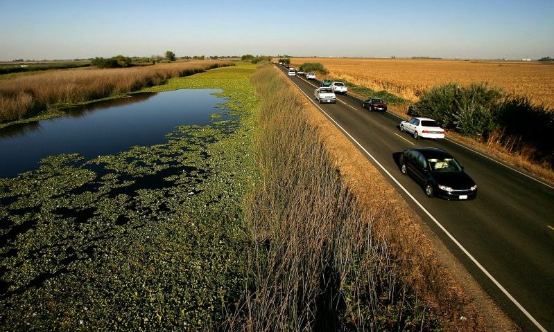 STOCKTON, CA - SEPTEMBER 28: Water is held back from a lower-elevation farm (R) by a section of Highway 4 that serves as a levee road in the Sacramento-San Joaquin River Delta, on September 28, 2005 west of Stockton, California. Officials say that the dikes of the Sacramento-San Joaquin River Delta are in worse shape than those that broke and flooded New Orleans during Hurricane Katrina. There is a two-in-three chance that a catastrophic earthquake or storm in the next 50 years will damage the levees enough to cause the kind destruction that engulfed New Orleans, according to experts. Such an event would affect the water supply that serves two-thirds of California and create a nightmare traffic jam on Highway 4, the two-lane road that would be the major evacuation route, if it is not damaged beyond usability. 1,600 miles of levees protect the delta?s islands, which lie well below sea-level, and most were built more than 100 years ago. (Photo by David McNew/Getty Images)