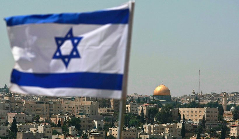 JERUSALEM - AUGUST 18: An Israeli flag flies from the Kidmat Zion Jewish settlement community on the outskirts of the Arab village of Abu Dis, where the Old City with its golden Dome of the Rock Islamic shrine is seen in the background, August 18, 2008 in East Jerusalem, Israel. The settlement, a stand-alone apartment building which houses a number of families, is a former Arab home purchased by the Ateret Cohanim organization which is dedicated to expanding Jewish settlement in East Jerusalem, the half of the city that Israel captured from Jordan in the 1967 Six Day War. (Photo by David Silverman/Getty Images)