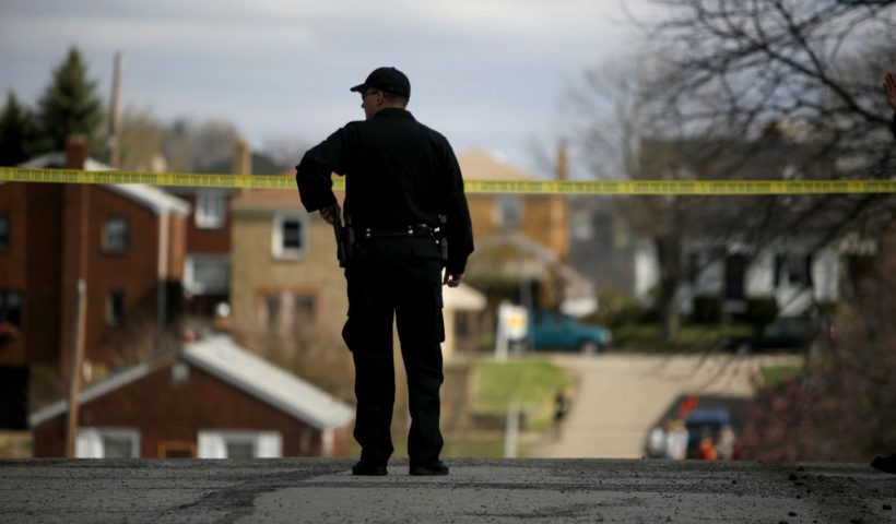 PITTSBURGH - APRIL 4: A police officer watches over the crime scene from a nearby corner April 4, 2009 in Pittsburgh, Pennsylvania. Five police officers were shot during a standoff with a suspect in the Stanton Heights neighborhood of Pittsburgh, after police responded to a domestic dispute. (Photo by Ross Mantle/Getty Images)