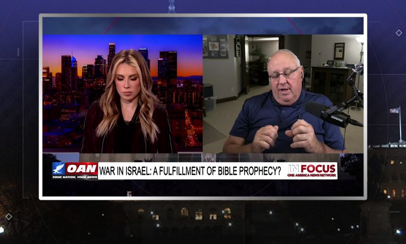 Video still from In Focus on One America News Network showing a split screen of the host on the left side, and on the right side is the guest, Pastor John Haller.