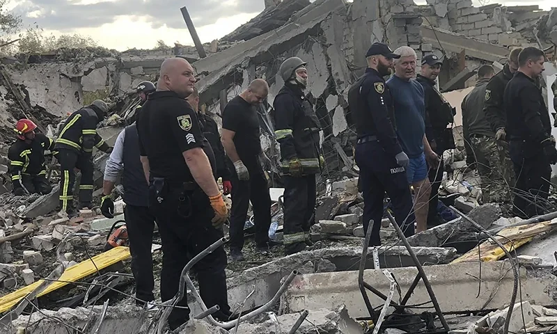 In this photo provided by the Ukrainian Police Press Office, emergency workers search the victims of the deadly Russian rocket attack that killed more than 40 people in the village of Hroza near Kharkiv, Ukraine, Thursday, Oct. 5, 2023. (Ukrainian Police Press Office via AP)