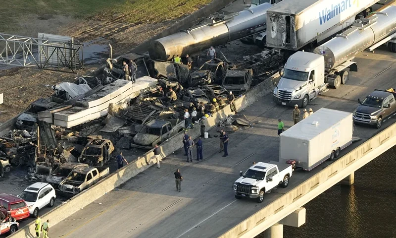 In this aerial photo, responders are seen near wreckage in the aftermath of a multi-vehicle pileup on I-55 in Manchac, La., Monday, Oct. 23, 2023. A "superfog" of smoke from south Louisiana marsh fires and dense morning fog caused multiple traffic crashes involving scores of cars. (AP Photo/Gerald Herbert)