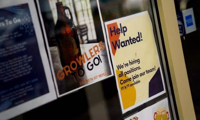 An employee hiring sign is seen in a window of a business in Arlington, Virginia, U.S., April 7, 2023. REUTERS/Elizabeth Frantz/File Photo