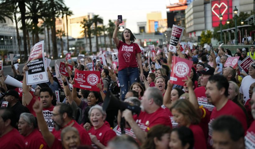 Members of the Culinary Workers Union rally along the Strip, Wednesday, Oct. 25, 2023, in Las Vegas. Thousands of hotel workers fighting for new union contracts rallied Wednesday night on the Las Vegas Strip, where rush-hour traffic was disrupted when some members blocked the road before being detained by police. (AP Photo/John Locher)