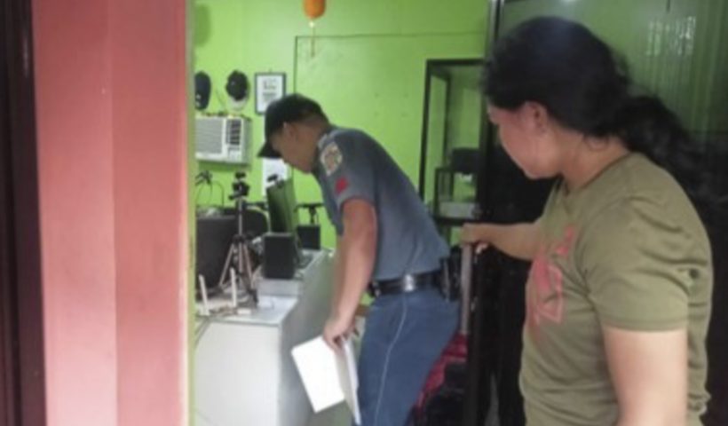 In this handout photo provided by the Calamba Municipal Police Station, a policeman, left, checks on the area where a radio anchor was fatally shot by a man inside his home-based station in Calamba town in Misamis Occidenta province, southern Philippines on Sunday Nov. 5, 2023. A radio anchor was fatally shot by a man inside his southern Philippine station Sunday in a brazen attack that was witnessed by people watching the program live on Facebook. (Calamba Municipal Police Station via AP)