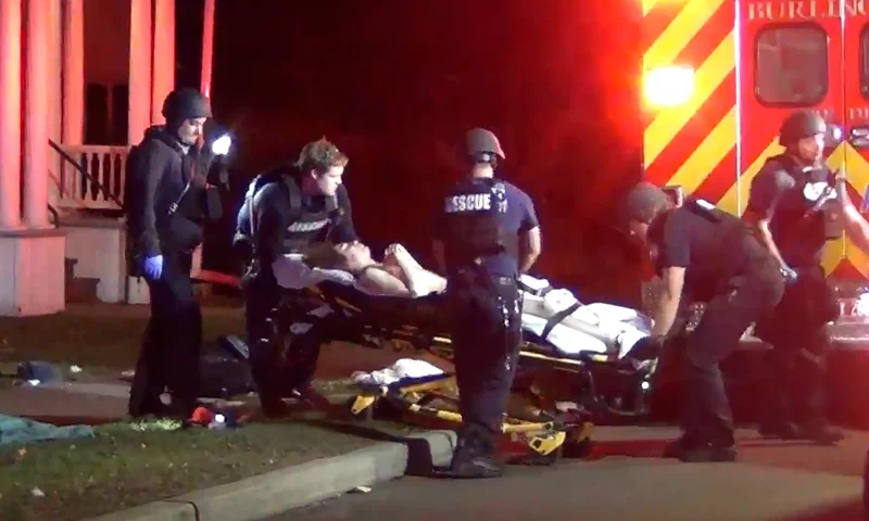 In a still frame from video first responders use a gurney to place an injured man into an ambulance while transporting him from the scene of a shooting, Saturday, Nov. 25, 2023, in Burlington, Vt. Burlington Police Department arrested Jason J. Eaton, suspected in the shooting of three young men of Palestinian descent, who were attending a Thanksgiving holiday gathering near the University of Vermont campus Saturday evening. (Wayne Savage via AP)