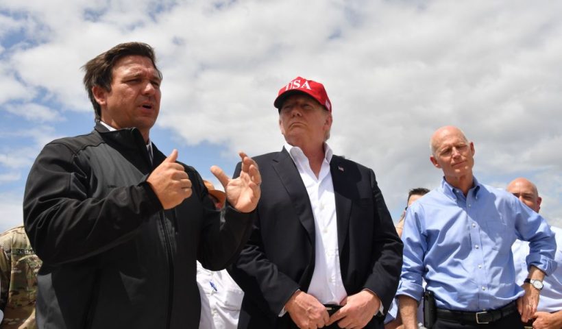 US President Donald Trump and Florida Republican US Senator Rick Scott (R) listen to Florida Governor Ron DeSantis (L) during a tour of the Edgar Hoover Dike on Lake Okeechobee in Florida, on March 29, 2019. (Photo by Nicholas Kamm / AFP) (Photo credit should read NICHOLAS KAMM/AFP via Getty Images)