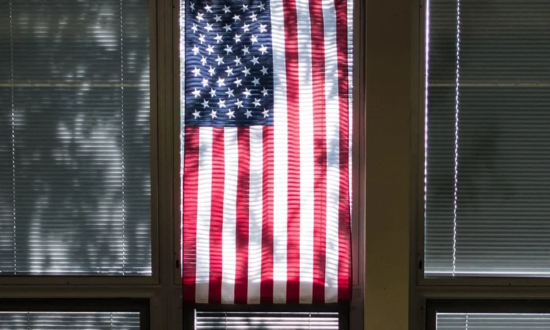 US-EDUCATION-SHOOTING-CRIME-GUNS A Sidney High School student waits for class under a US flag in Sidney, Ohio, October 31, 2019. At the entrance to Sidney High School in small-town Ohio, there is a poster which reads: "Inside this building, our children are protected by an armed and trained response team." In rural Shelby County, law enforcement has trained teachers to fight back, should an attacker threaten students. They are among the first in the United States to embrace the controversial strategy. (Photo by Megan JELINGER / AFP) (Photo by MEGAN JELINGER/AFP via Getty Images)