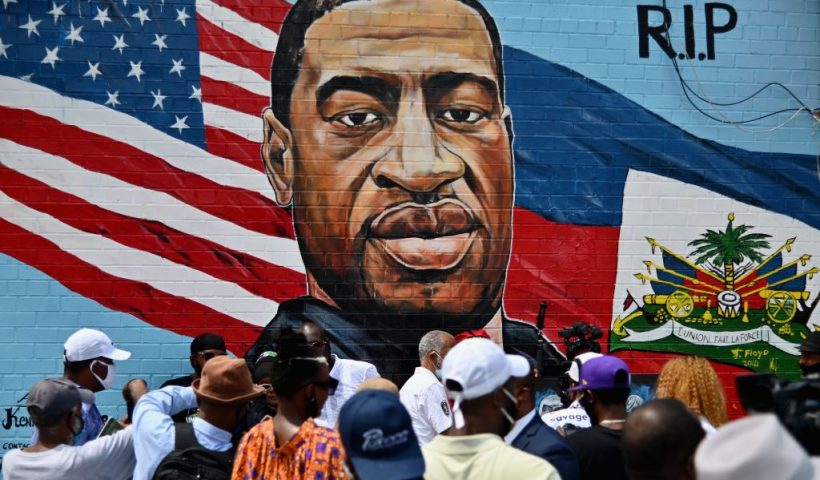 TOPSHOT - People gather at the unveiling of artist Kenny Altidor's memorial portrait of George Floyd - who died 25 May in Minneapolis with police officer Derek Chauvin kneeling on his neck for nearly nine minutes - painted on a storefront sidewall of CTown Supermarket on July 13, 2020 in Brooklyn, New York. (Photo by Angela Weiss / AFP) / RESTRICTED TO EDITORIAL USE - MANDATORY MENTION OF THE ARTIST UPON PUBLICATION - TO ILLUSTRATE THE EVENT AS SPECIFIED IN THE CAPTION (Photo by ANGELA WEISS/AFP via Getty Images)