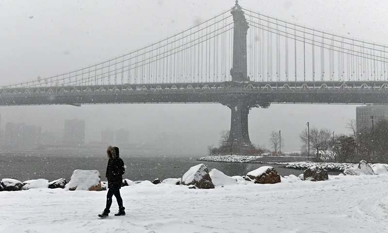 TOPSHOT - A person walks through the snow in New York, on February 18, 2021. - A historic winter weather system that brought bitter, record-busting cold to much of the southern and central US was pushing up the East Coast on Thursday, with forecasters warning of heavy snowfall and dangerous, icy buildups. The frigid blast has over the past week seen Arctic cold envelope the US heartland unfamiliar with such extremes, leaving dozens of dead in its wake and millions of people in oil-rich Texas without power. (Photo by Angela Weiss / AFP) (Photo by ANGELA WEISS/AFP via Getty Images)