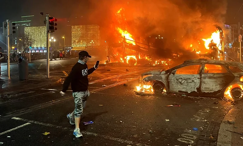 IRELAND-INCIDENT-POLICE-CHILDREN-EMERGENCY Flames rise from a car and a bus, set alight at the junction of Bachelors Walk and the O'Connell Bridge, in Dublin on November 23, 2023, as people took to the streets in protest following the stabbings earlier in the day. Protesters in Dublin on Thursday torched a car and fought police, an AFP journalist reported, after three children were injured in a suspected school stabbing that social media rumours attributed to a foreign national. (Photo by Peter MURPHY / AFP) (Photo by PETER MURPHY/AFP via Getty Images)