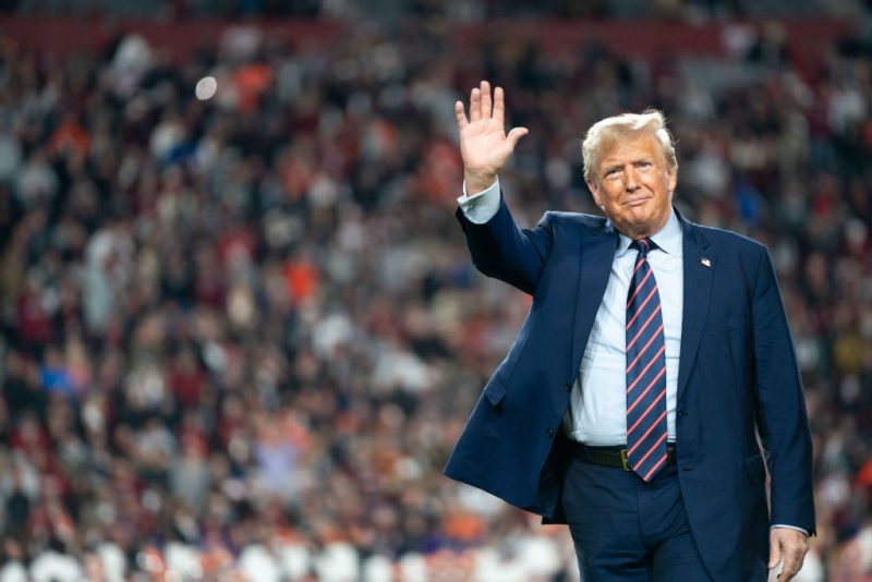 COLUMBIA, SOUTH CAROLINA - NOVEMBER 25: Former U.S. President Donald Trump waves to the crowd on the field during halftime in the Palmetto Bowl between Clemson and South Carolina at Williams Brice Stadium on November 25, 2023 in Columbia, South Carolina. Trump attended the rivalry game in a key early-voting state as he campaigns ahead of next year’s Republican presidential primary. (Photo by Sean Rayford/Getty Images)
