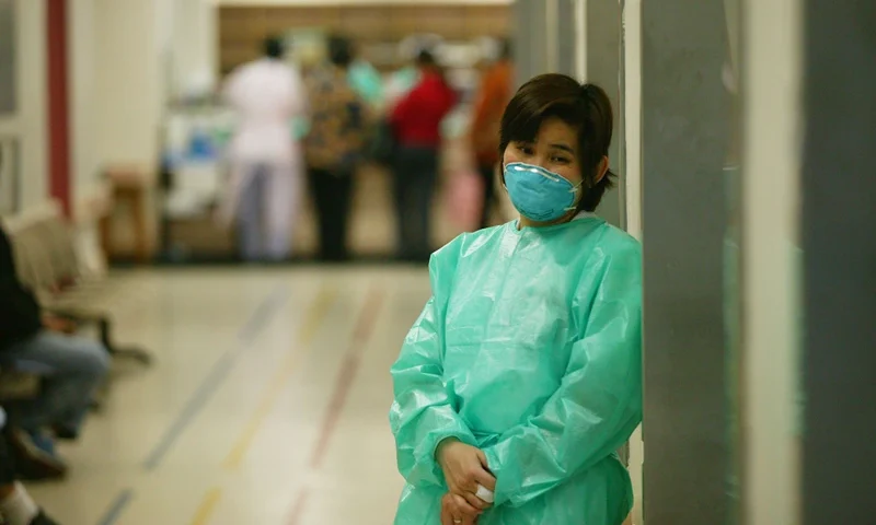 Mystery Illness Causes Panic In Hong Kong HONG KONG - MARCH 14: A staff member at the Prince of Wales hospital wears a face masks in an effort to protect herself from a deadly and contagious respiratory virus March 14, 2003 in Hong Kong. The illness has killed one person, a 50-year-old American businessman, and infected over 90 people, including medical personnel throughout Hong Kong hospitals. The World Health Organization has sent a global alert after flu outbreaks in Hanoi and Hong Kong and has collected samples from patients to see if a virus or bacteria is causing the mystery illness. (Photo by Christian Keenan/Getty Images)