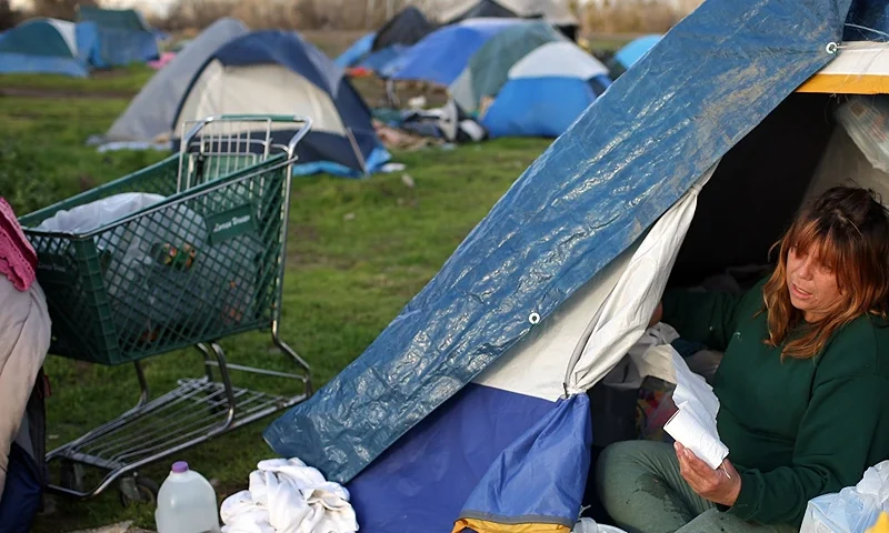 SACRAMENTO, CA - MARCH 04: Karen Hersh, an out of work truck driver, cleans her tent at a homeless tent city March 4, 2009 in Sacramento, California. The tent city is seeing an increase in population as the economy worsens and more people are becoming unemployed and having their homes slip into foreclosure. (Photo by Justin Sullivan/Getty Images)