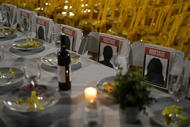 A table is set for hostages being held in the Gaza Strip, in a show of solidarity, in Tel Aviv, Israel Saturday, Nov. 25, 2023. Egyptian officials said Hamas was preparing to release 14 Israeli hostages Saturday for 42 Palestinian prisoners held by Israel. (AP Photo/Leo Correa)