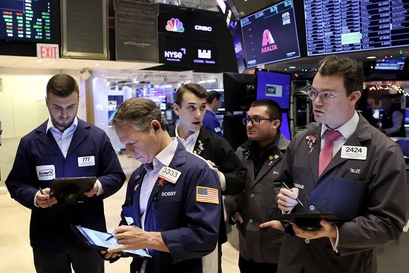 Traders gather at the post that trades Alaska Airlines stock on the floor at the New York Stock Exchange (NYSE) in New York City, U.S., December 4, 2023. REUTERS/Brendan McDermid/File Photo