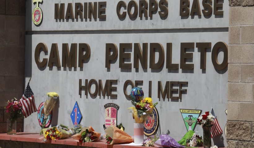 OCEANSIDE, CA - AUGUST 27: Flowers and other keepsakes adorn the entrance sign to Camp Pendleton on August 27, 2021 in Oceanside, California. 170 people were killed, including 13 U.S. Servicemen during an ISIS-led terrorist attack outside of the Kabul Airport. (Photo by Sandy Huffaker/Getty Images)