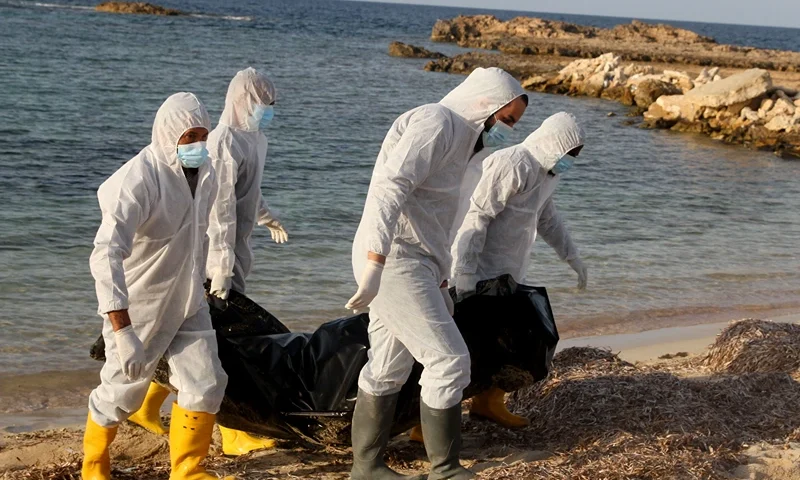 TOPSHOT-LIBYA-MIGRATION-EU TOPSHOT - Libyan health workers recover bodies of drowned migrants, who were hoping to travel to Europe by sea, after a shipwreck off the beach in Sabratha, some 120 kilometres west of the Libyan capital Tripoli, on November 25, 2021. (Photo by AFP) (Photo by -/AFP via Getty Images)