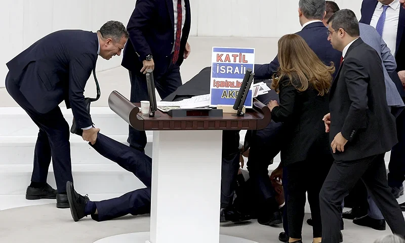 Felicity Party (Saadet) Deputy Hasan Bitmez (C) is attended to as he lies on the floor after collapsing whilst delivering his speech on the 2024 Ministry of Justice and Ministry of Internal Affairs budget, in the Turkish Grand National Assembly (TBMM) in Ankara on December 12, 2023. (Photo by Adem ALTAN / AFP) (Photo by ADEM ALTAN/AFP via Getty Images)