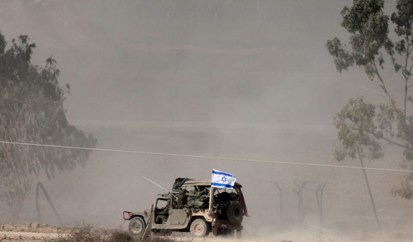 A picture taken in southern Israel near the border with the Gaza Strip on December 12, 2023, shows an Israeli army vehicle carrying soldiers into northern Gaza, amid continuing battles between Israel and the militant group Hamas. (Photo by Menahem KAHANA / AFP) (Photo by MENAHEM KAHANA/AFP via Getty Images)