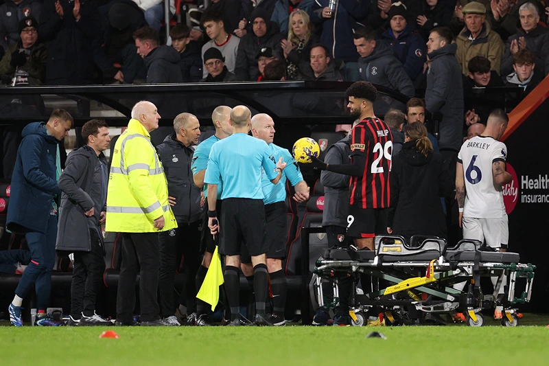 AFC Bournemouth v Luton Town - Premier League
BOURNEMOUTH, ENGLAND - DECEMBER 16: Referee Simon Hooper is handed the match ball by Philip Billing of AFC Bournemouth as players of Luton Town and AFC Bournemouth leave the field as Tom Lockyer of Luton Town (not pictured) receives medical treatment after collapsing during the Premier League match between AFC Bournemouth and Luton Town at Vitality Stadium on December 16, 2023 in Bournemouth, England. (Photo by Warren Little/Getty Images)